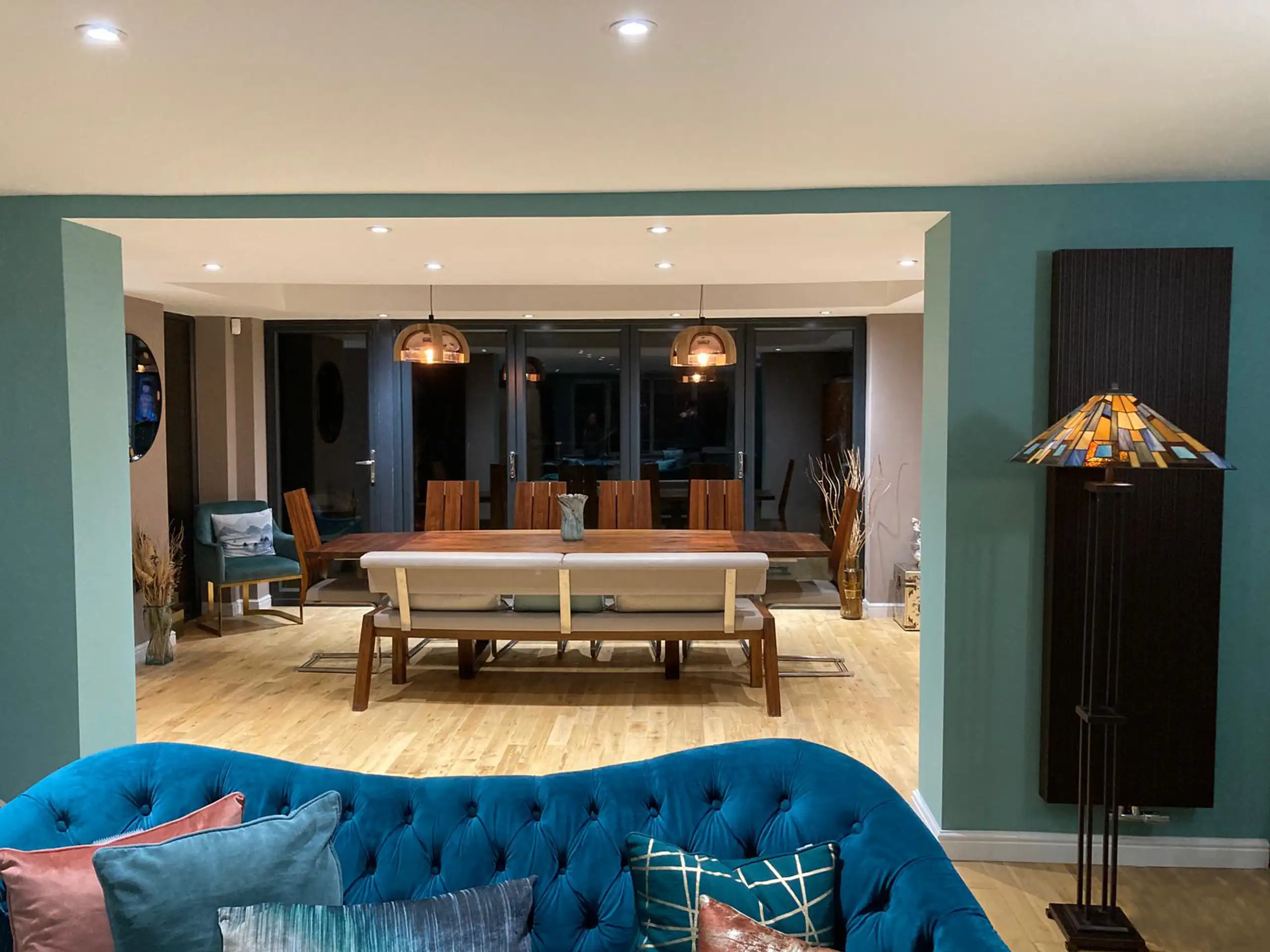 Close-up view of modern living room showcasing teal walls and wooden furniture.
