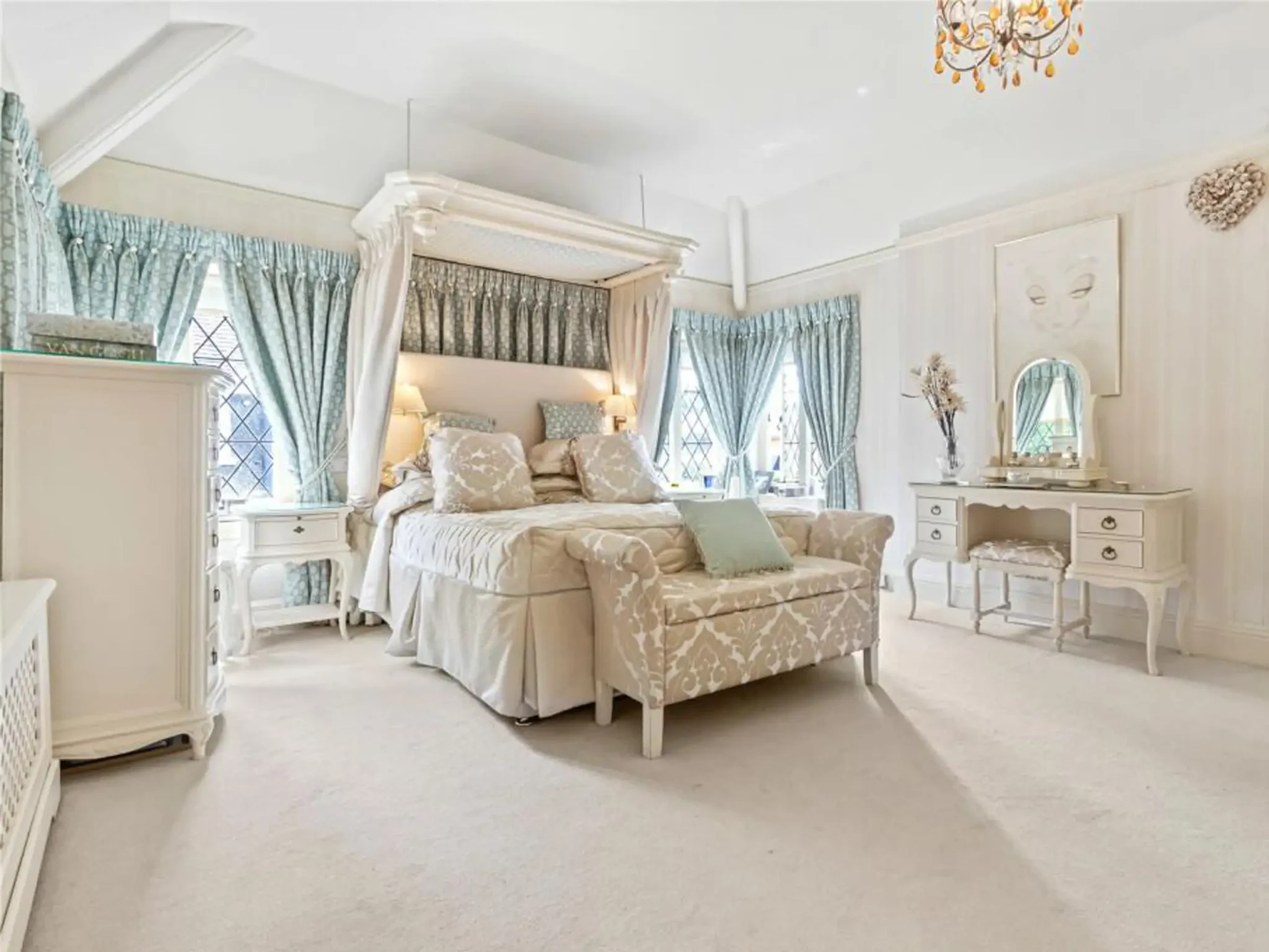 Luxurious bedroom with canopy bed, ornate white furniture, and soft pastel décor in Hale, Cheshire.