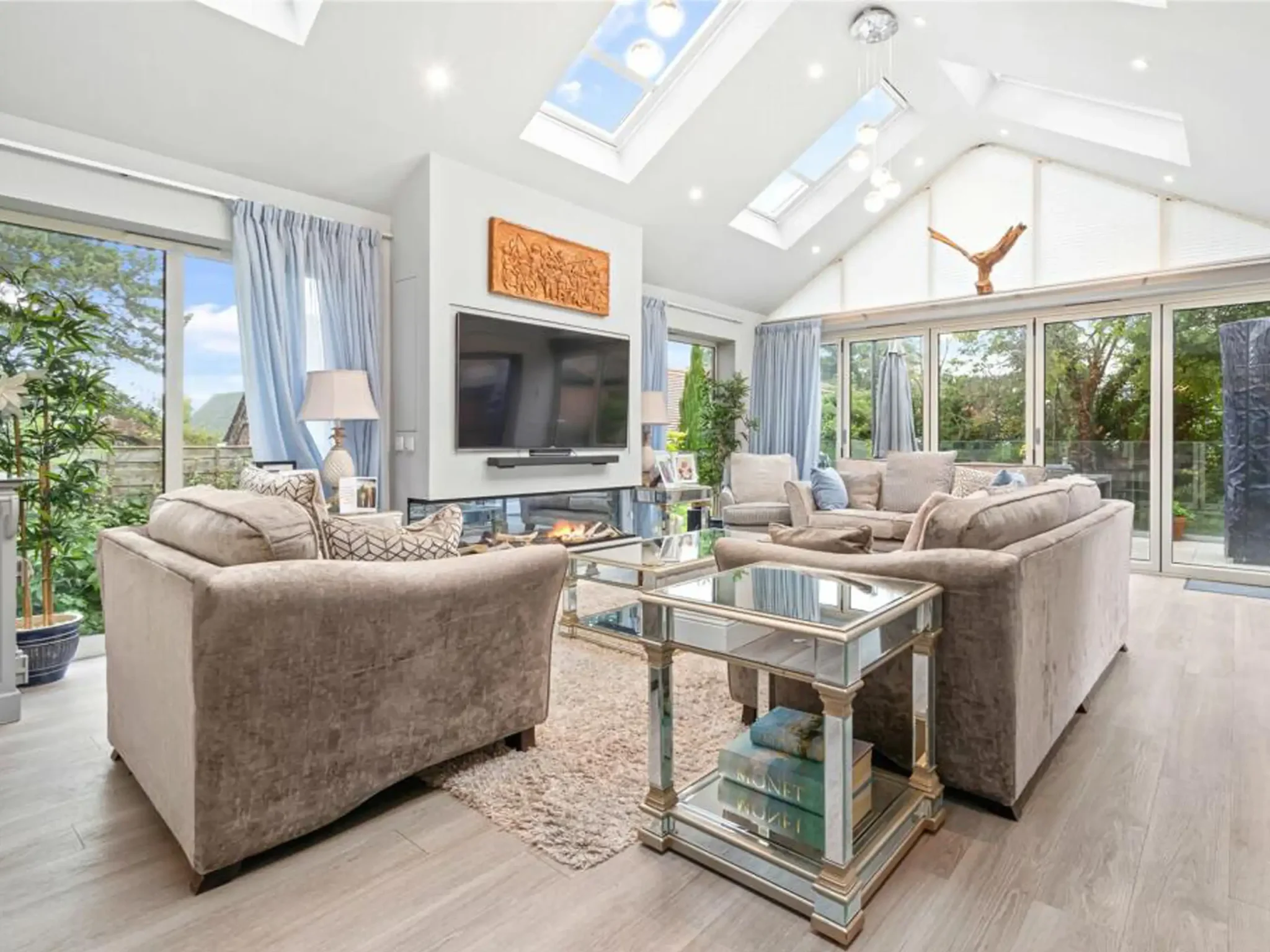 Hale, Cheshire family living room with skylights, sliding glass doors and layered lighting in a soft neutral palette by The Space Whisperer